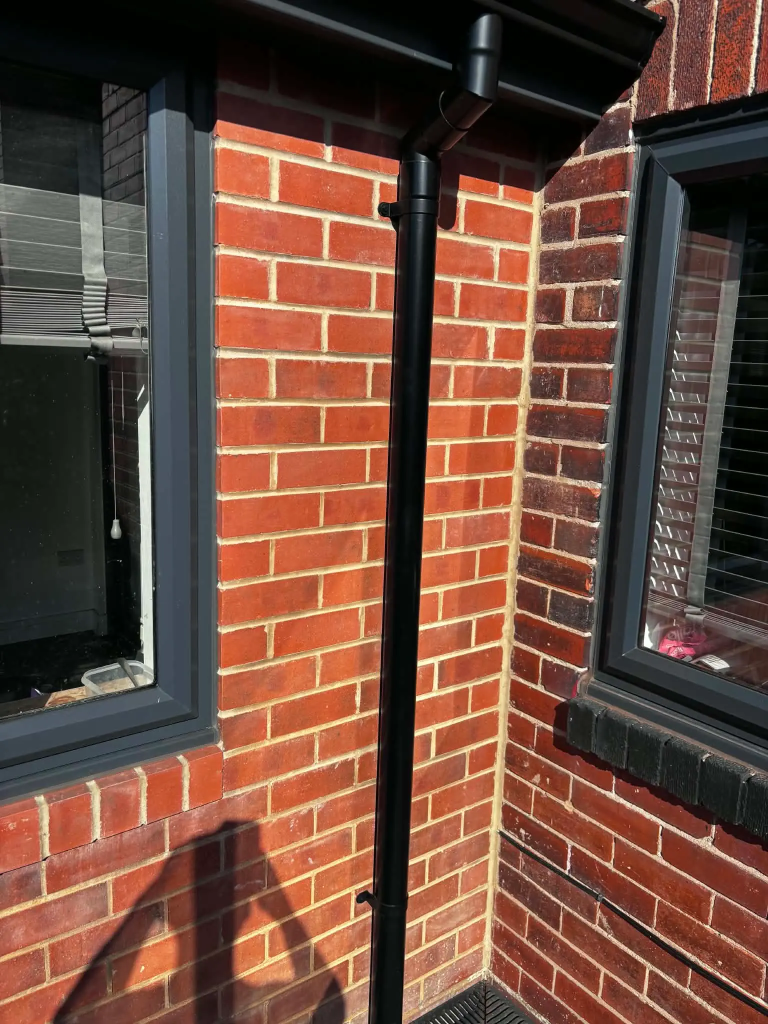 Downpipe secured neatly against exterior wall