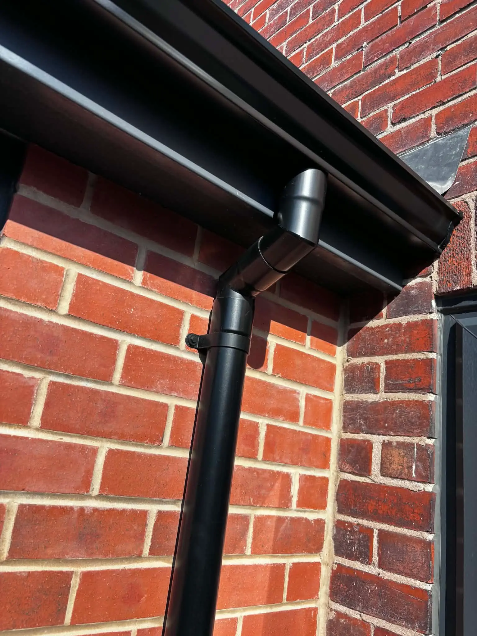 Close-up of gutter outlet connected neatly to downpipe