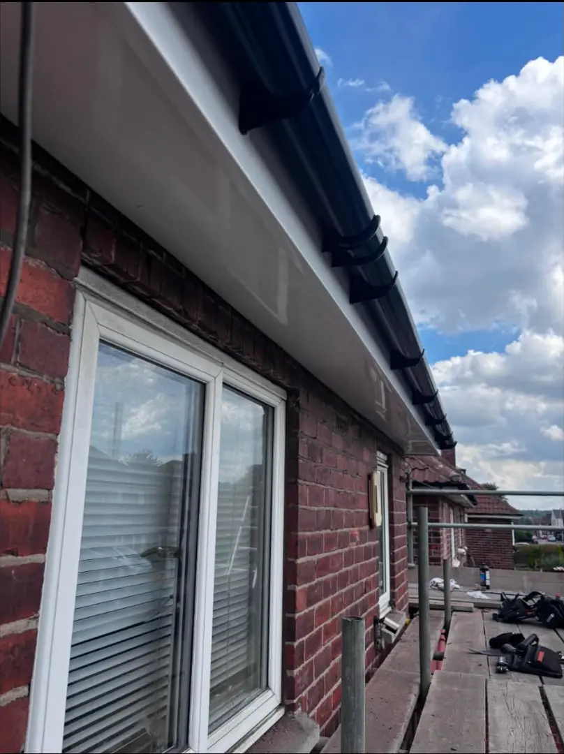 Completed white fascia and soffit installation with black guttering
