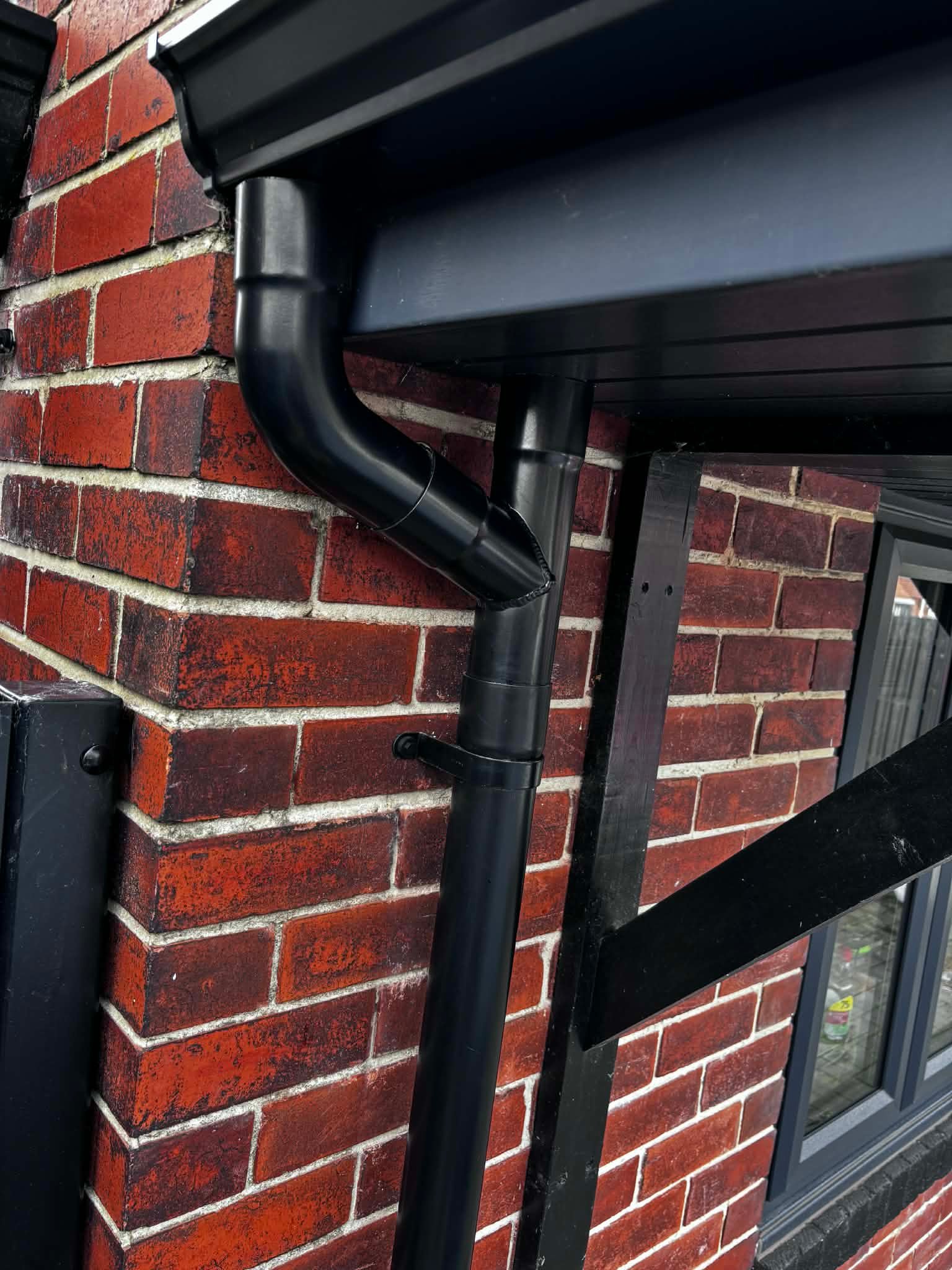 Close-up UPVC downpipe installation detail in Doncaster
